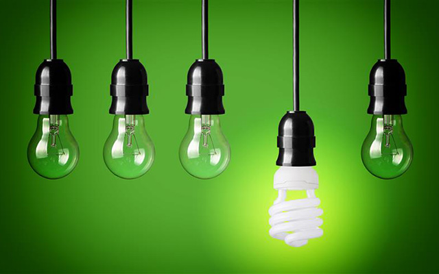 four unlit light bulbs hang alongside one lit eco bulb
