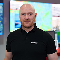 Head and shoulders of a man in a black t-shirt