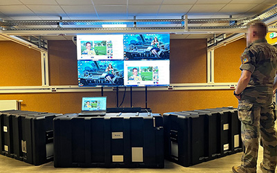 a soldier stands in front of a mobile videowall