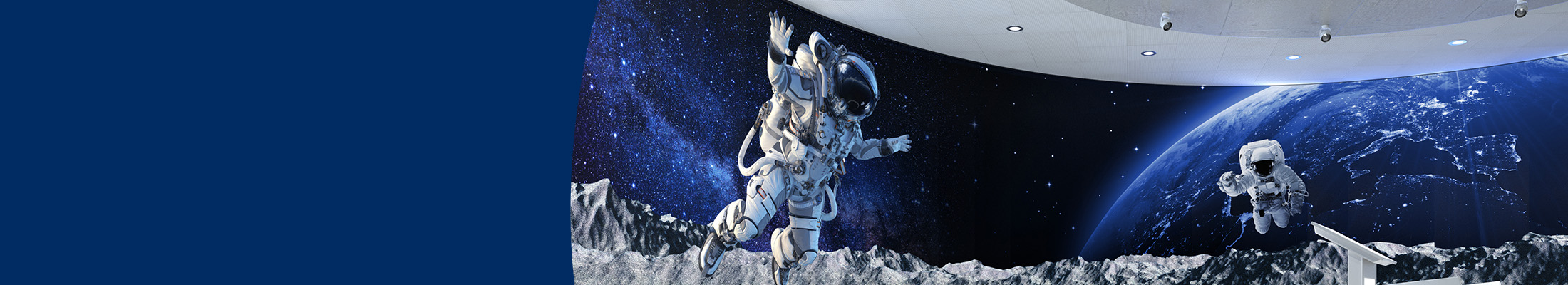 a huge, curved LED wall shows a space scene with two astronauts