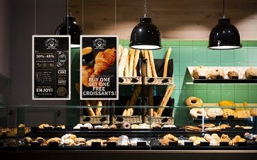 Two posters display promotions in a bakery